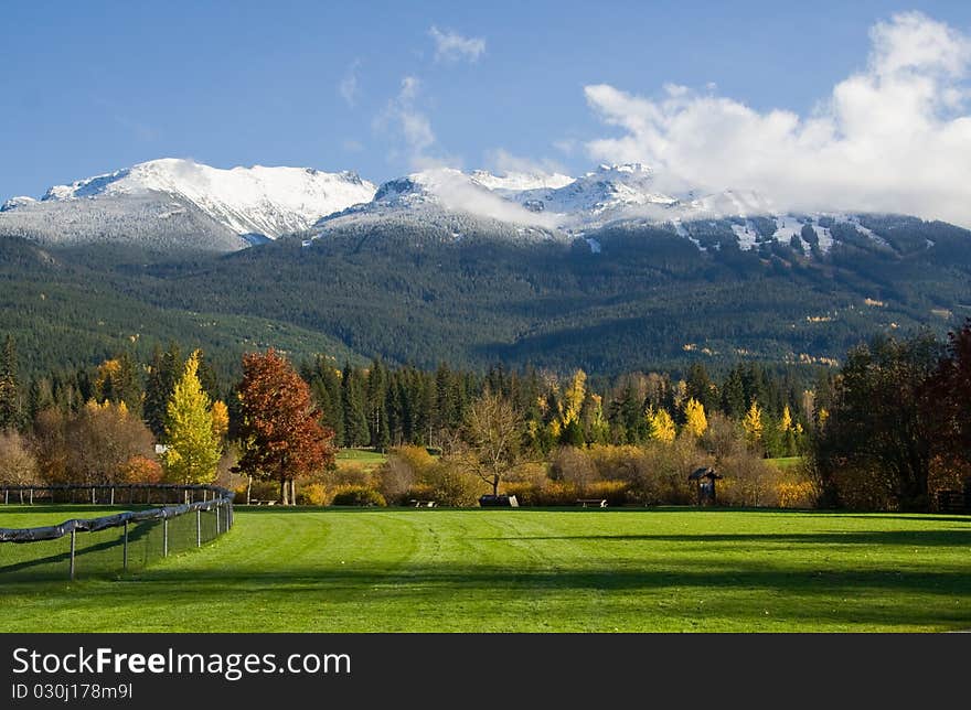 The early autumn snow on the top of the mountains viewed from nearby park. The early autumn snow on the top of the mountains viewed from nearby park