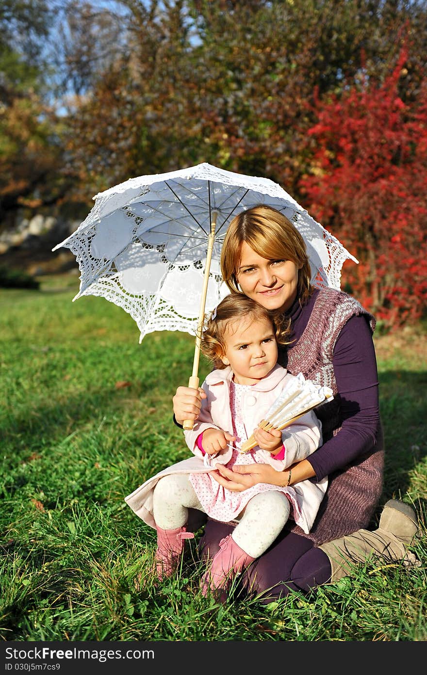 Happy family, mom and little girl under umbrella. Happy family, mom and little girl under umbrella