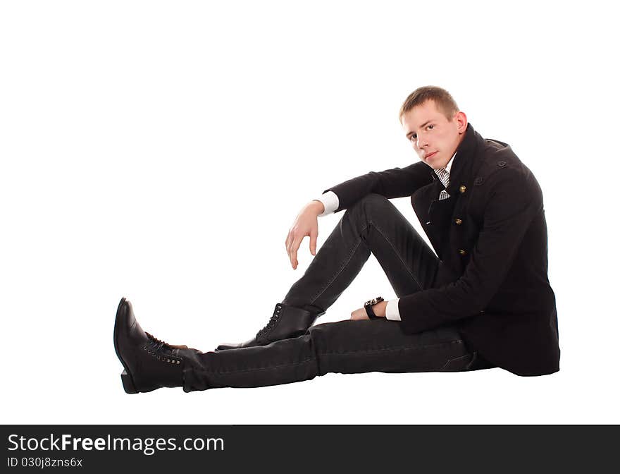 The serious man sitting on a floor against a white background. The serious man sitting on a floor against a white background.