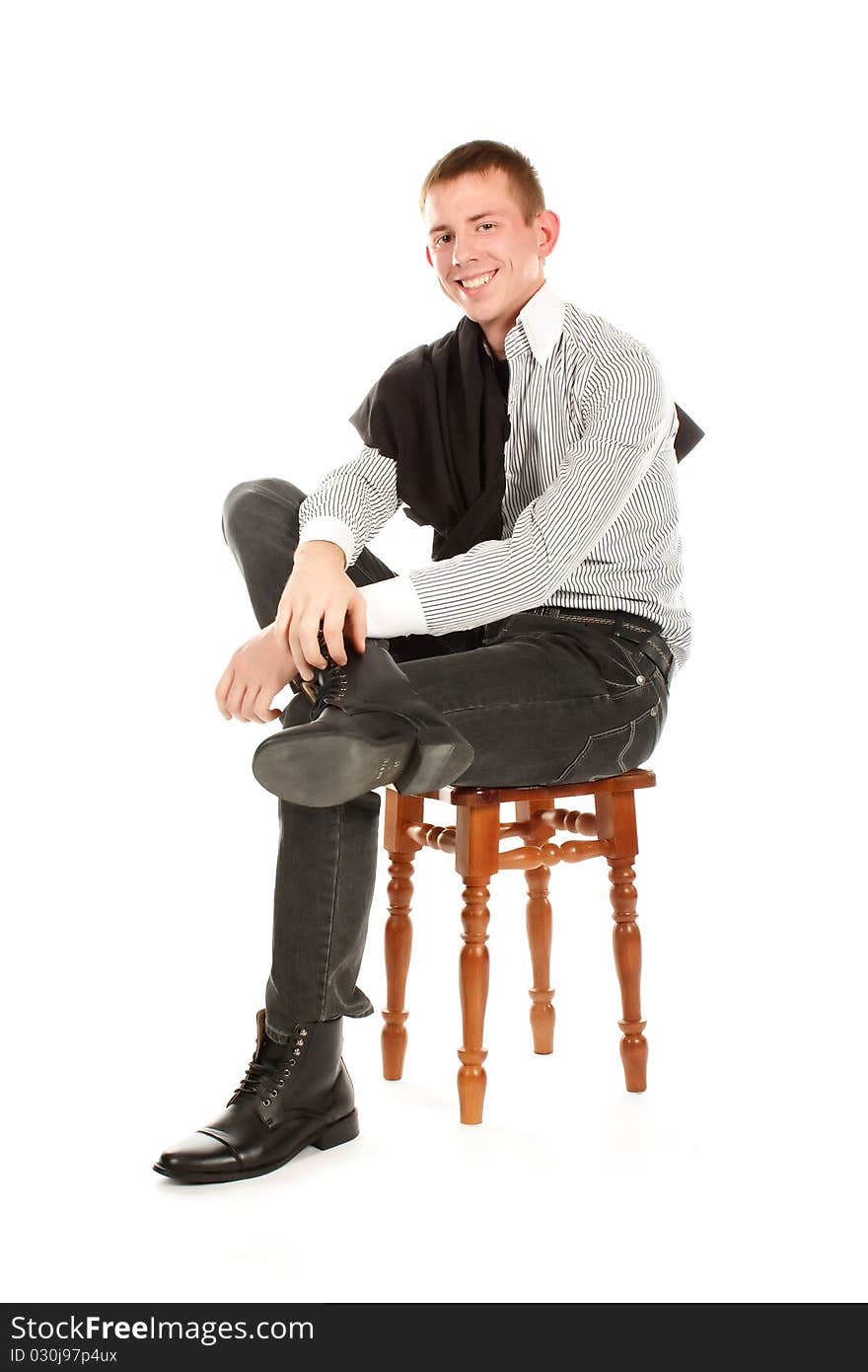 The serious man sitting on a chair and smiling against a white background. The serious man sitting on a chair and smiling against a white background.