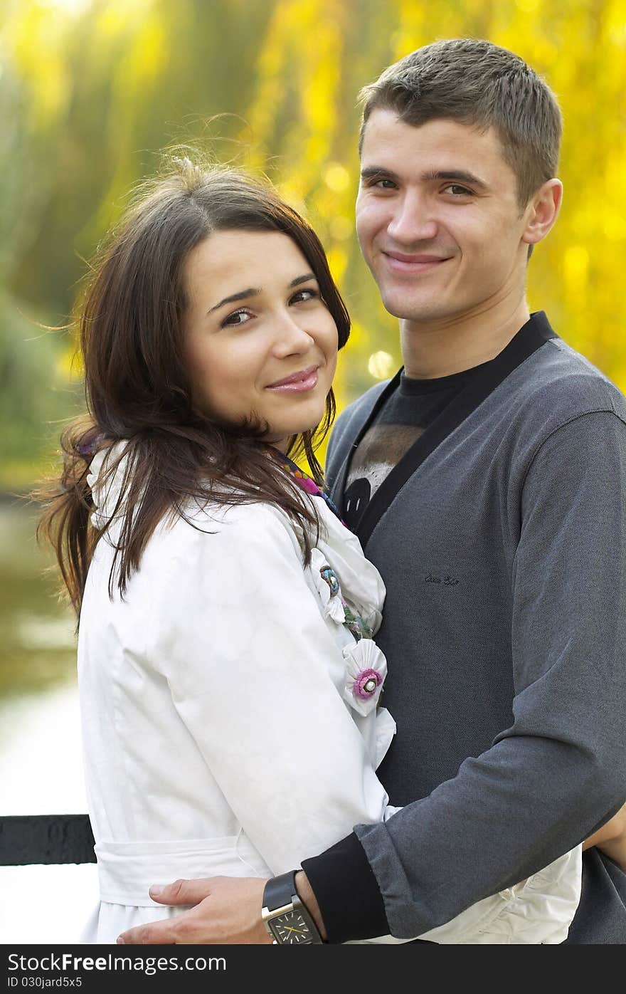 Young couple portrait over defocused autumn park background. Young couple portrait over defocused autumn park background