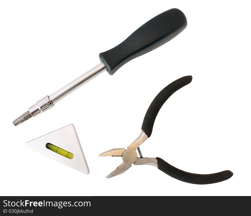 Three tools: screw-driver with replaceable tip, pliers and small triangular level. Isolated on white without shadow. Three tools: screw-driver with replaceable tip, pliers and small triangular level. Isolated on white without shadow.