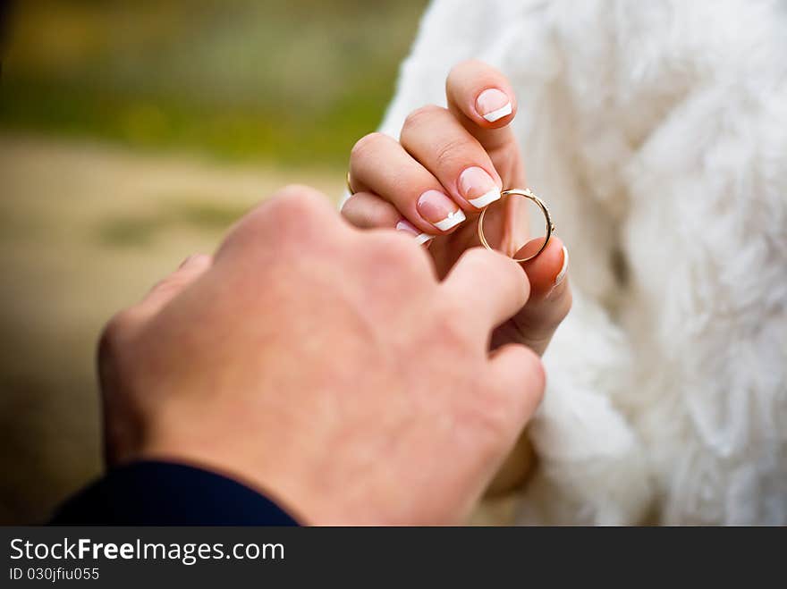 Putting on a wedding ring outdoors