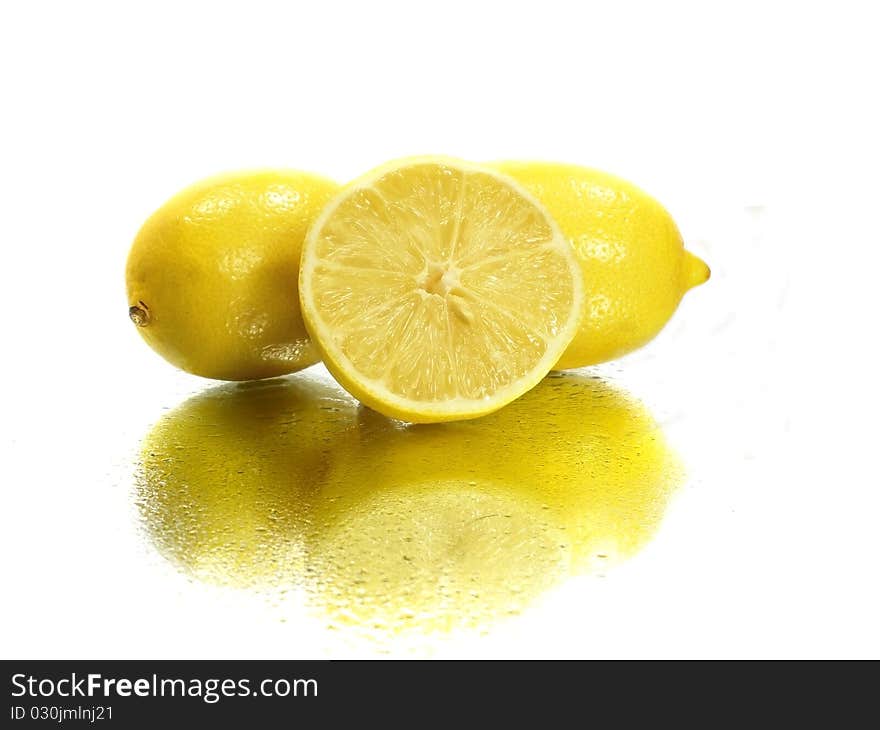 Fresh lemons on the white background with water drops