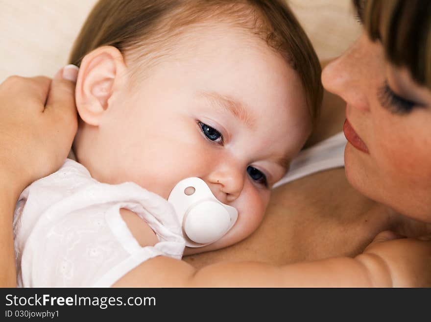 Closeup portrait of a young mother with her little daughter relaxing at home. Closeup portrait of a young mother with her little daughter relaxing at home