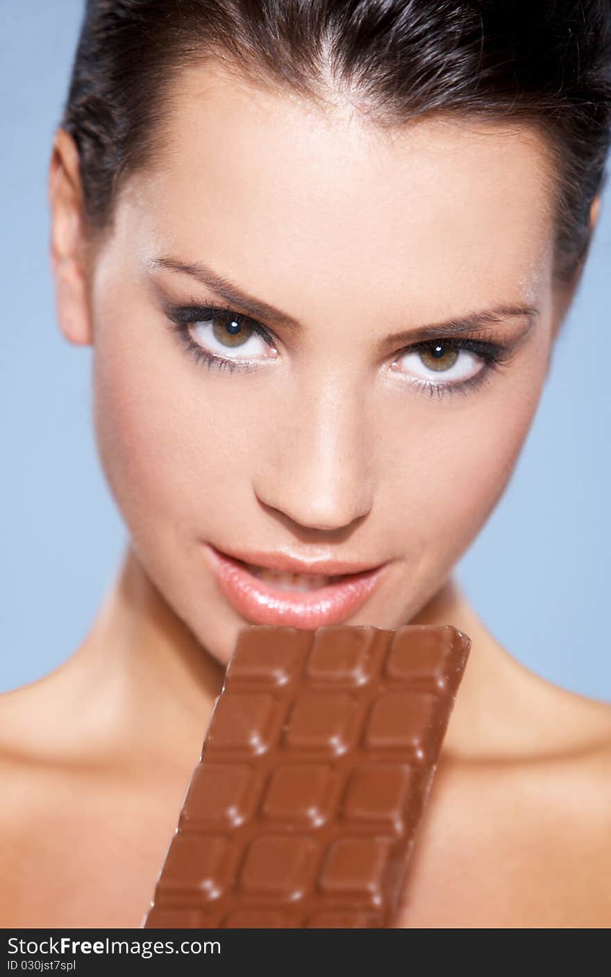 Portrait of beautiful woman, she holding chocolate bar, isolated on blue. Portrait of beautiful woman, she holding chocolate bar, isolated on blue