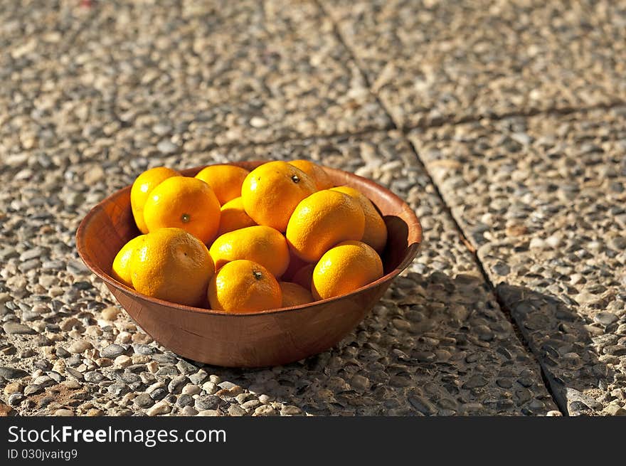 Fresh oranges in a wooden bowl