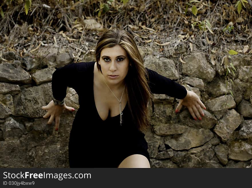 View of a beautiful woman next to a wall.