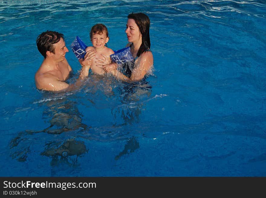 Family with a child in swimming pool. Family with a child in swimming pool