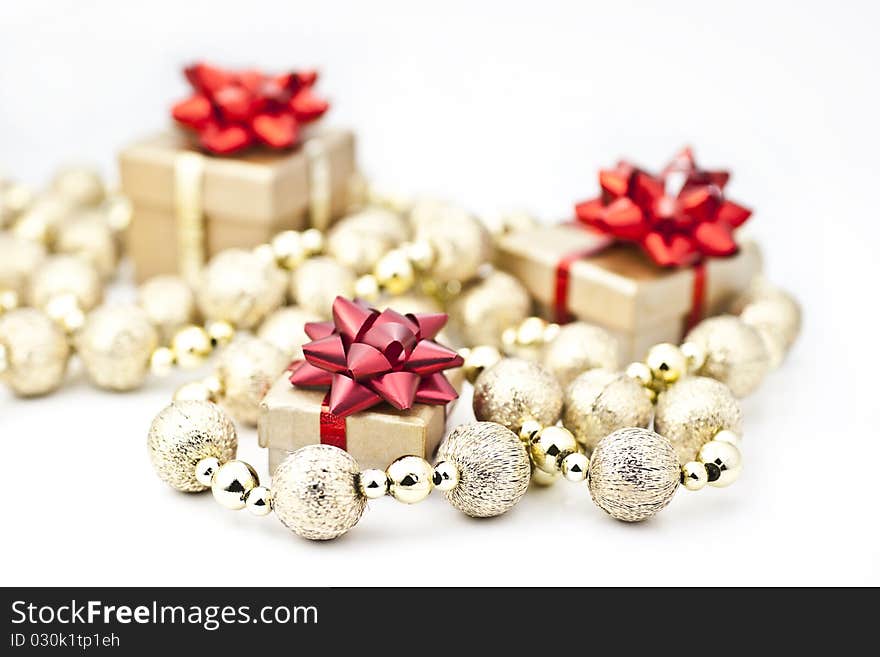 On a white background golden gift box with red tassels of golden ball strings. On a white background golden gift box with red tassels of golden ball strings.