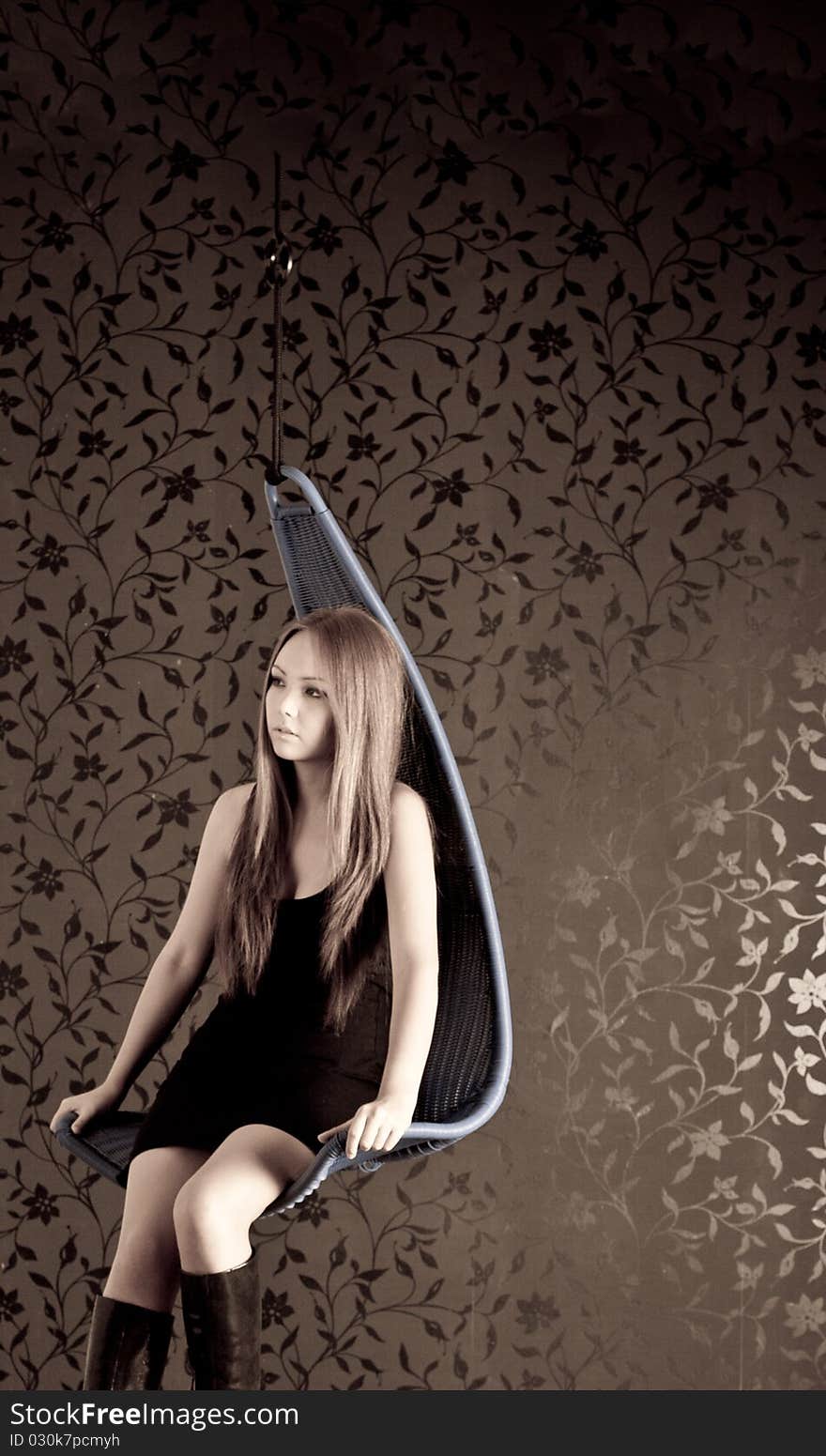 A girl sits on a swing