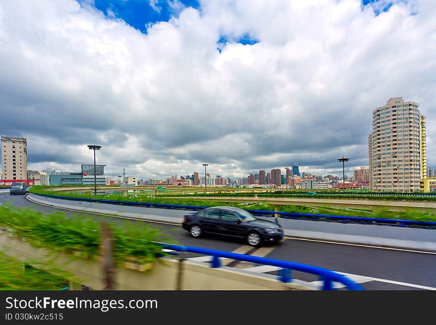 Road through the bridge with blue sky background of a city.