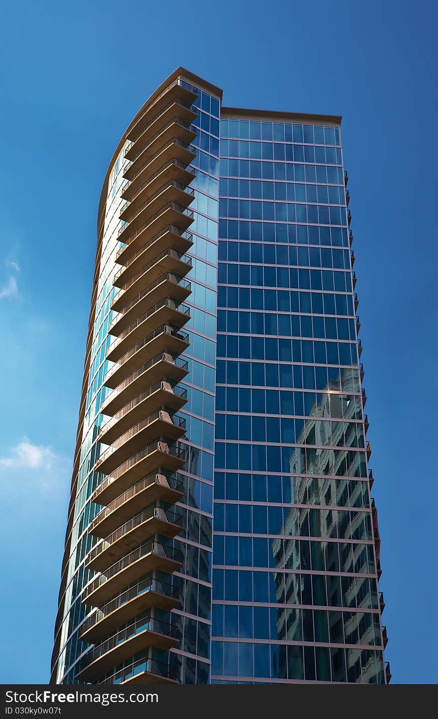 Modern skyscraper against blue sky and cloud