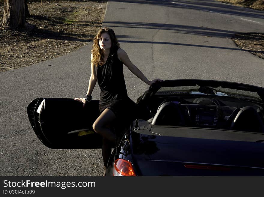 View of a beautiful woman exiting a sports car. View of a beautiful woman exiting a sports car.