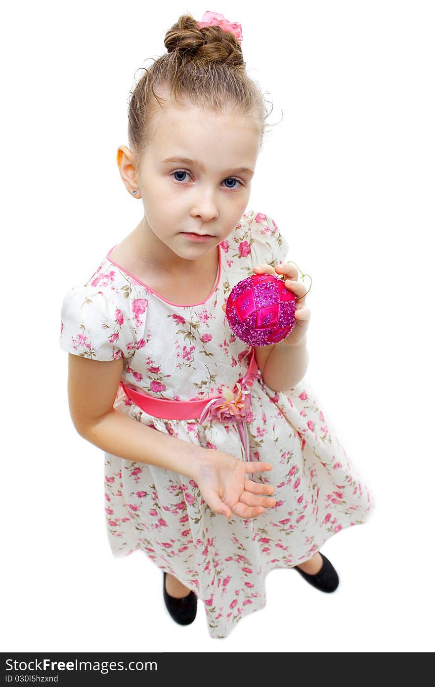 High angle view of a little cute girl playing with a tree-decoration ball. High angle view of a little cute girl playing with a tree-decoration ball