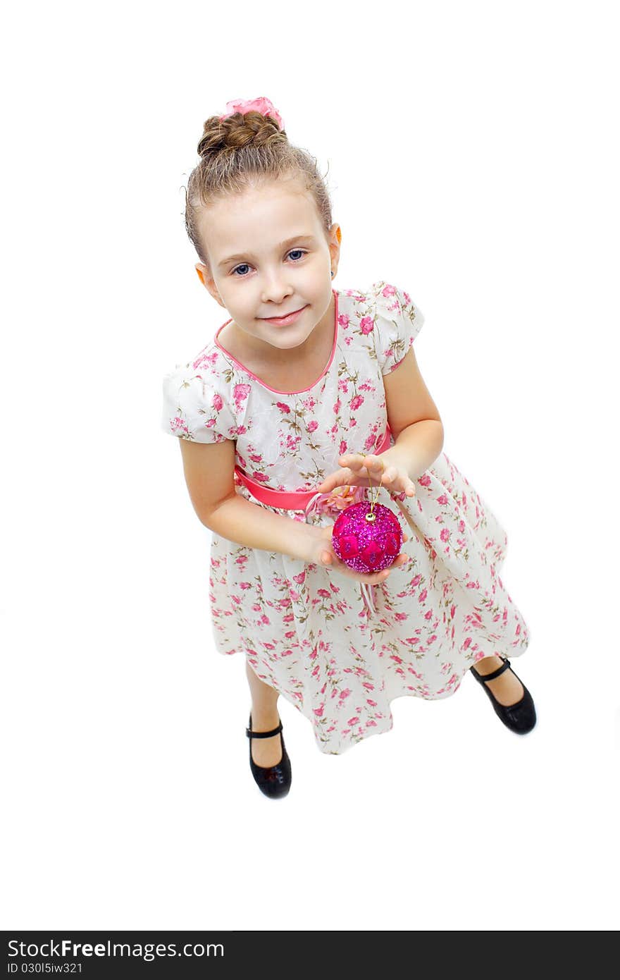 High angle view of a little cute girl playing with a tree-decoration ball. High angle view of a little cute girl playing with a tree-decoration ball