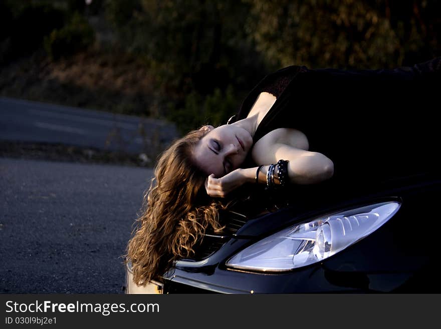 View of a beautiful woman on top of a sports car. View of a beautiful woman on top of a sports car.