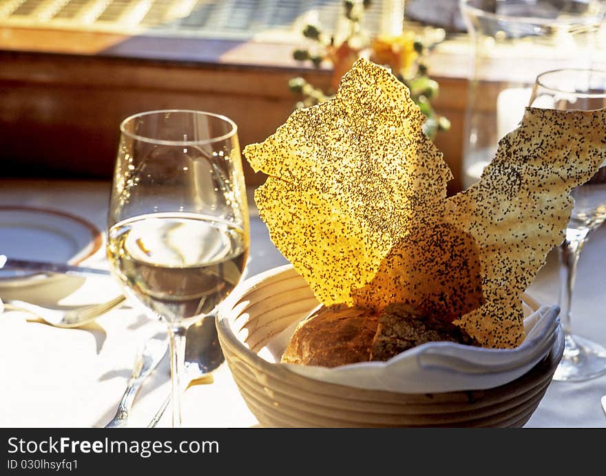 Bread in a basket with a glass of white wine. Bread in a basket with a glass of white wine.