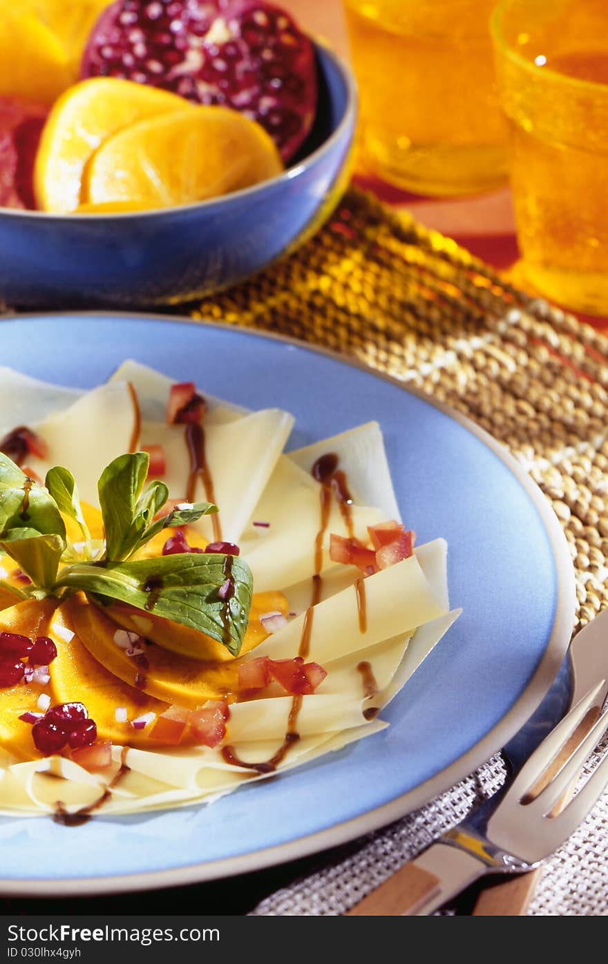 Carpaccio on blue plate with decoration in the background.