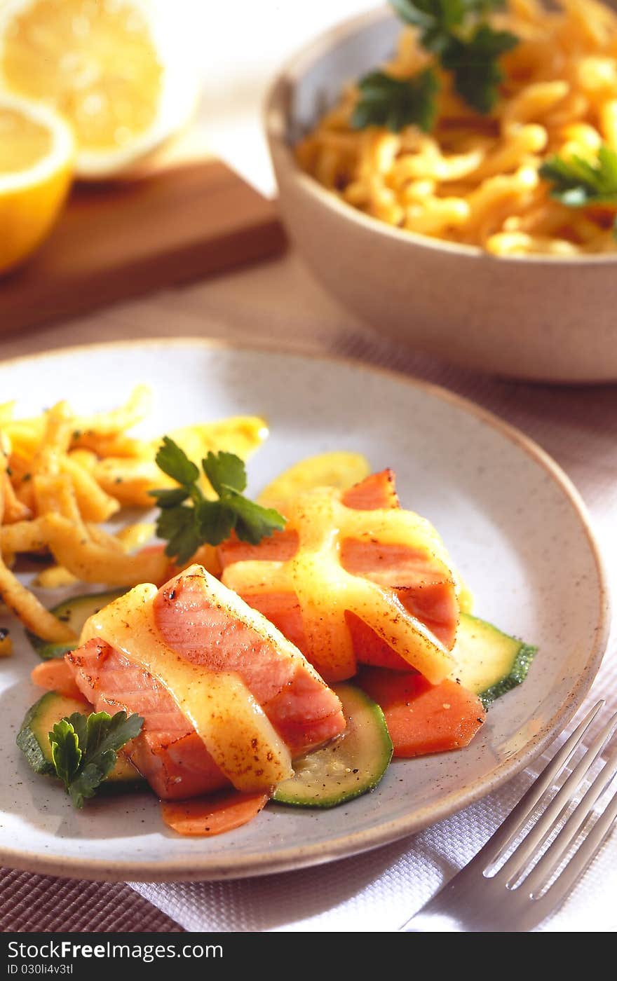 Salmon medallions with cucumber and lemon in the background