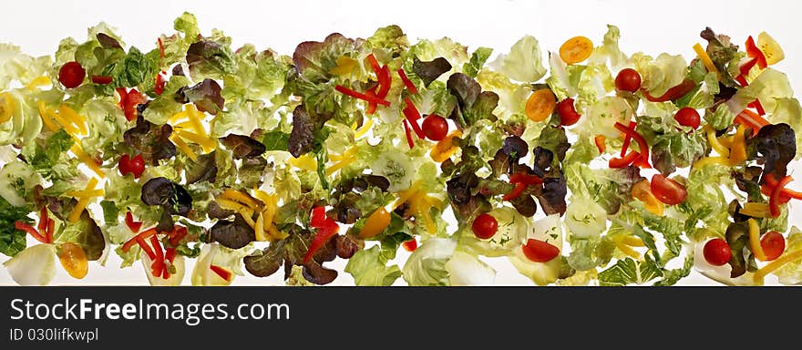 Long strip of salad leaves on white background.