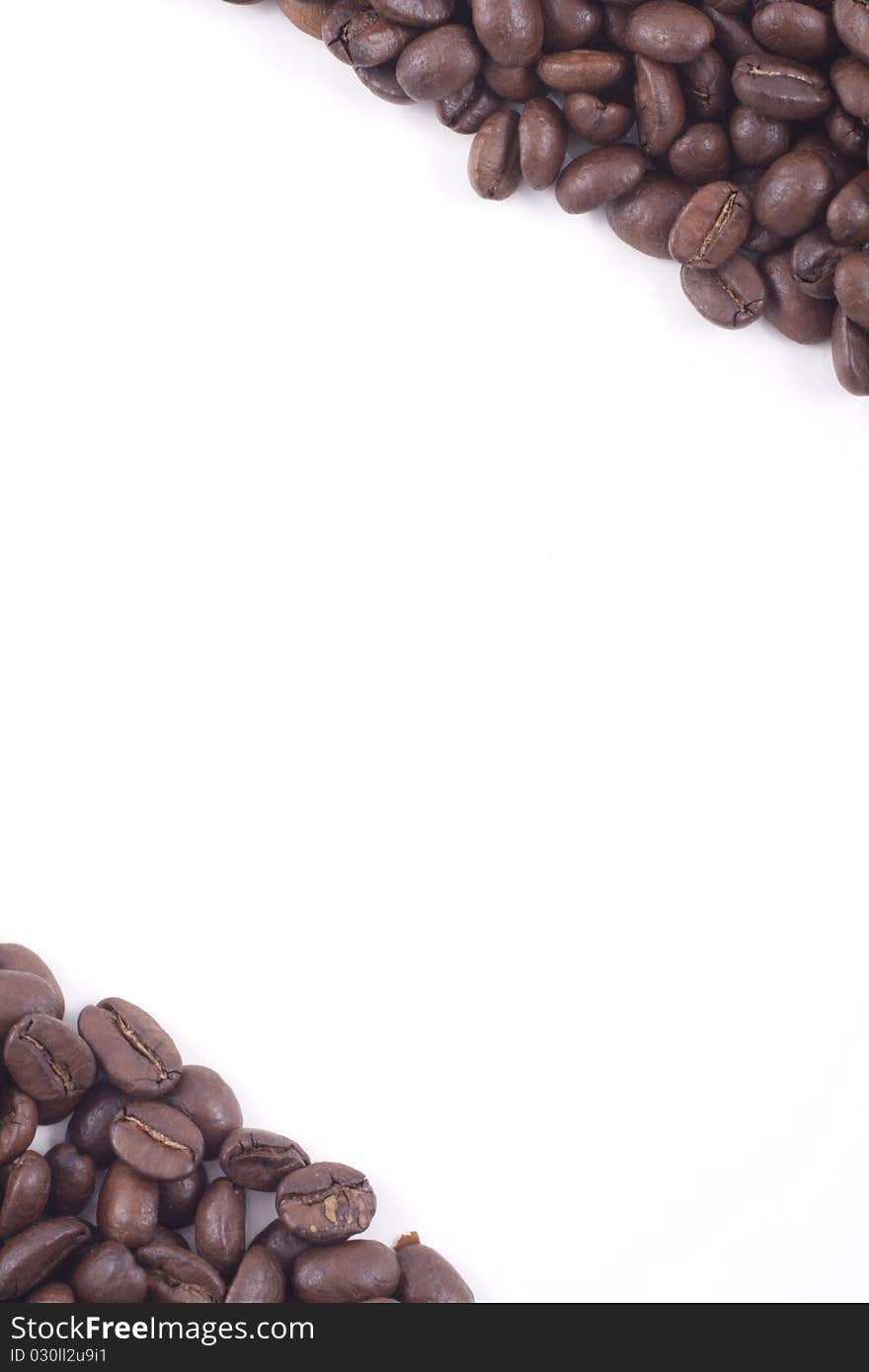 Dark roasted fair trade coffee beans framing a white background. Dark roasted fair trade coffee beans framing a white background