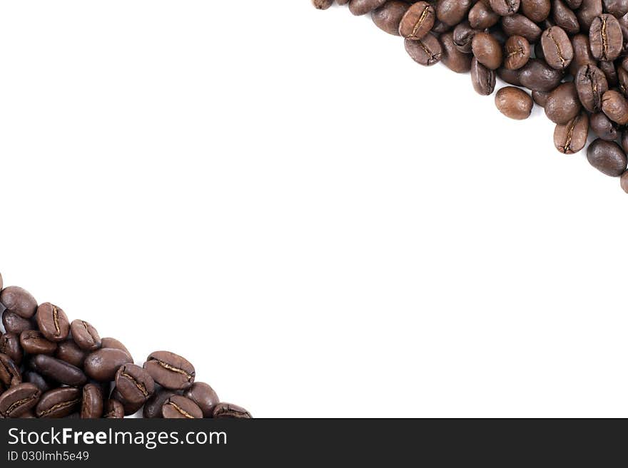 Frame of dark roasted coffee beans in the corners on a white background