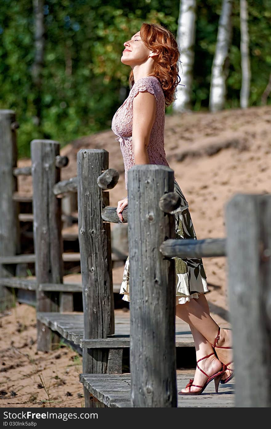 Red-haired adult woman in dune near the sea