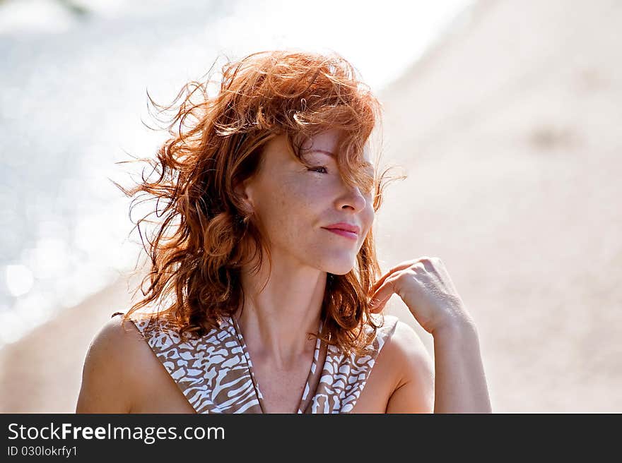 Portrait of red-haired adult women in dune at the sea. Portrait of red-haired adult women in dune at the sea