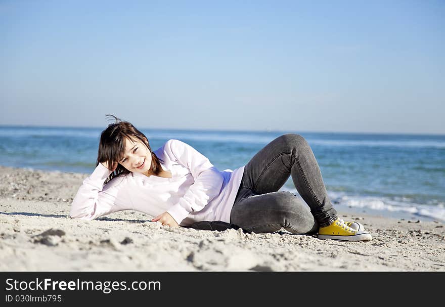 Portrait of brunette girl at the beach. Outdoor shot.