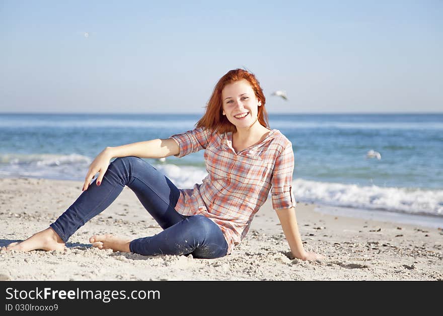 Happy red-haired girl at the beach.