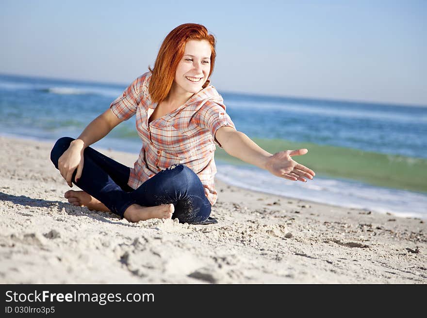 Happy red-haired girl at the beach. Outdoor shot.