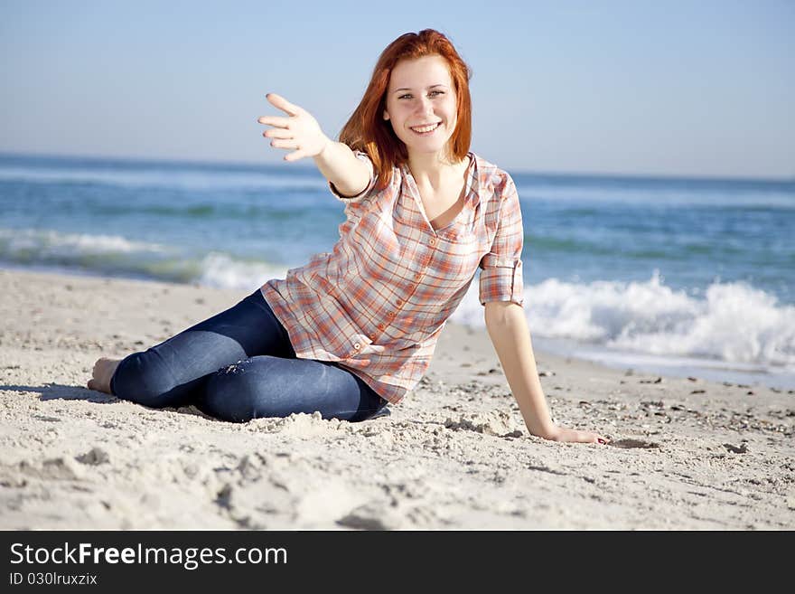 Happy red-haired girl at the beach. Outdoor shot.