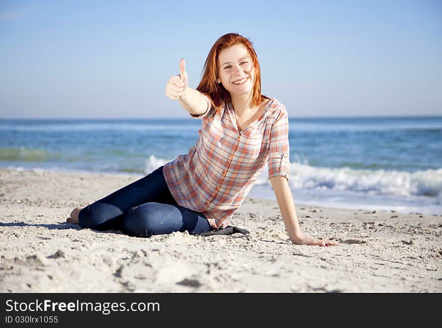 Happy red-haired girl at the beach. Outdoor shot.