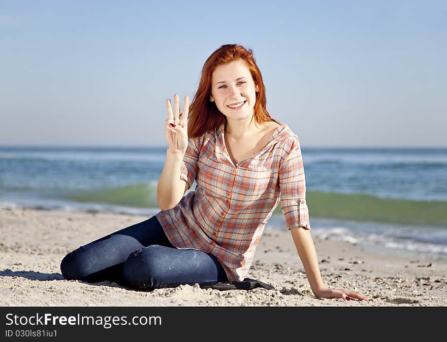 Happy red-haired girl at the beach. Outdoor shot.