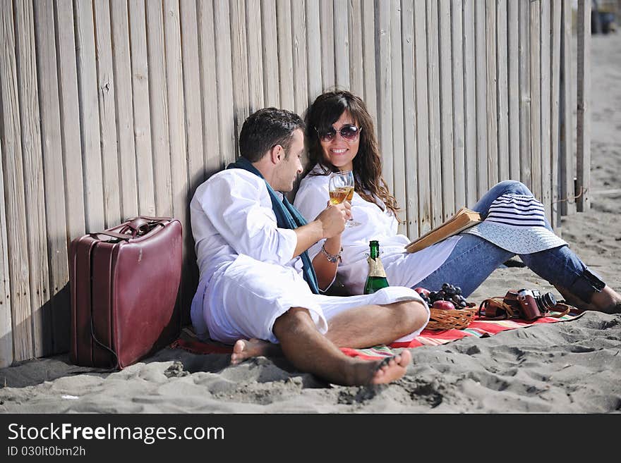 Happy young couple enjoying picnic on the beach and have good time on summer vacations. Happy young couple enjoying picnic on the beach and have good time on summer vacations