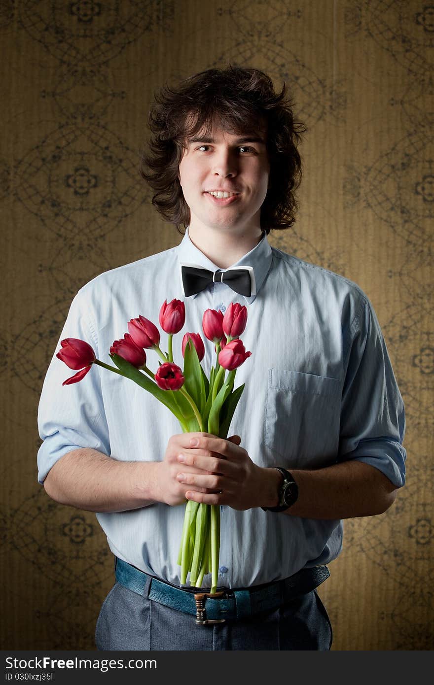 An image of handsome man with red tulips. An image of handsome man with red tulips