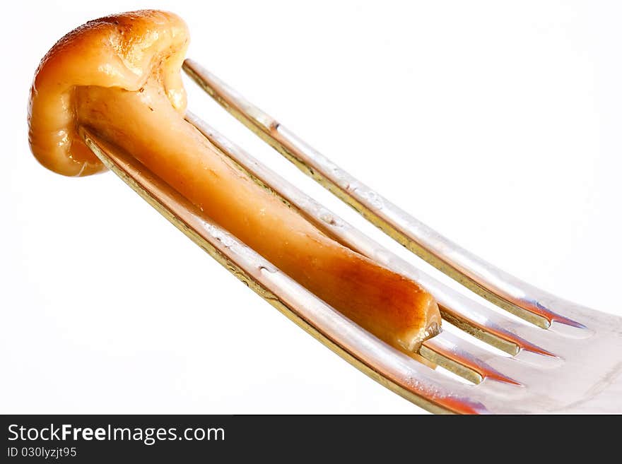 Boiled mushroom impaled on a fork before eating