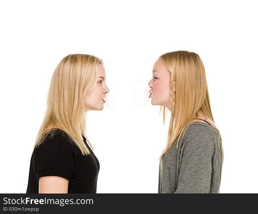 Two girls making bubbles of Bubble Gum isolated on white background