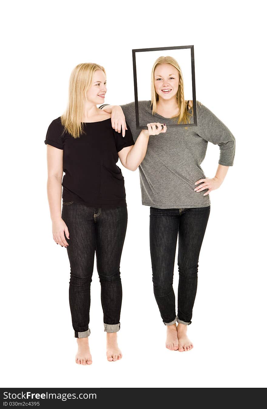 Girl holding a frame in front of her friends face. Girl holding a frame in front of her friends face