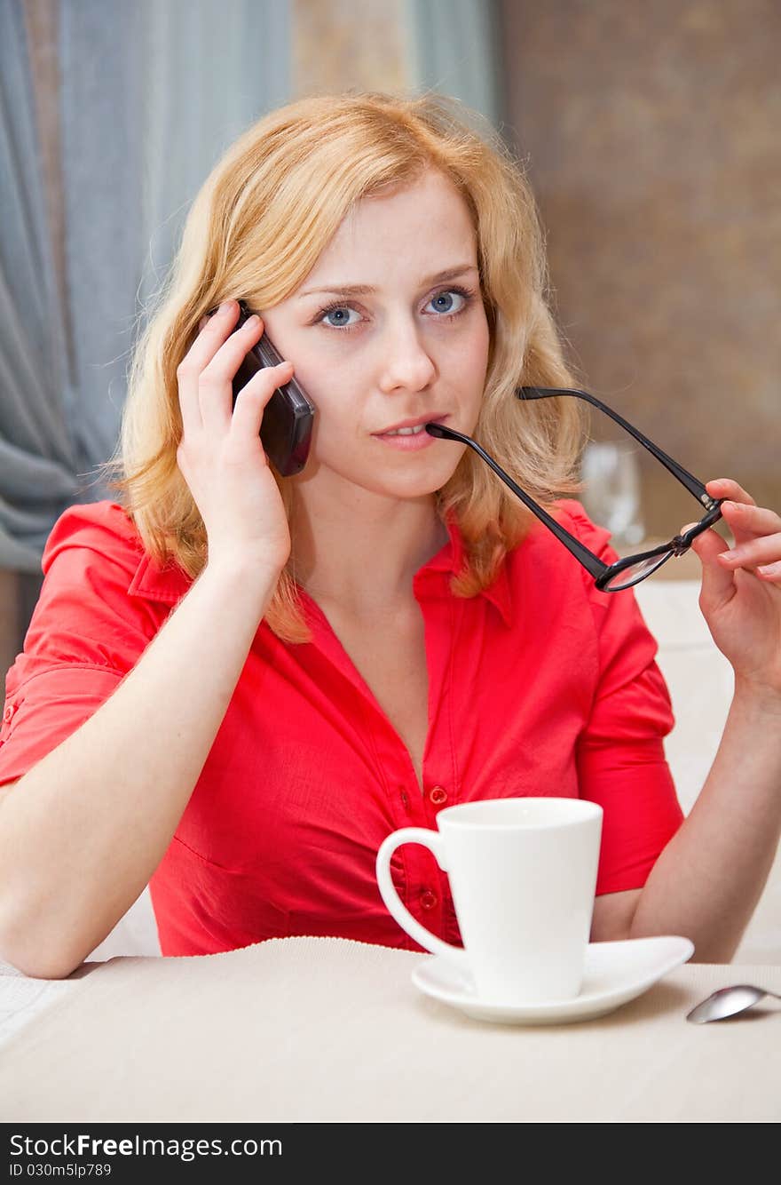 A beautiful woman is talking on the mobile phone in cafe. A beautiful woman is talking on the mobile phone in cafe