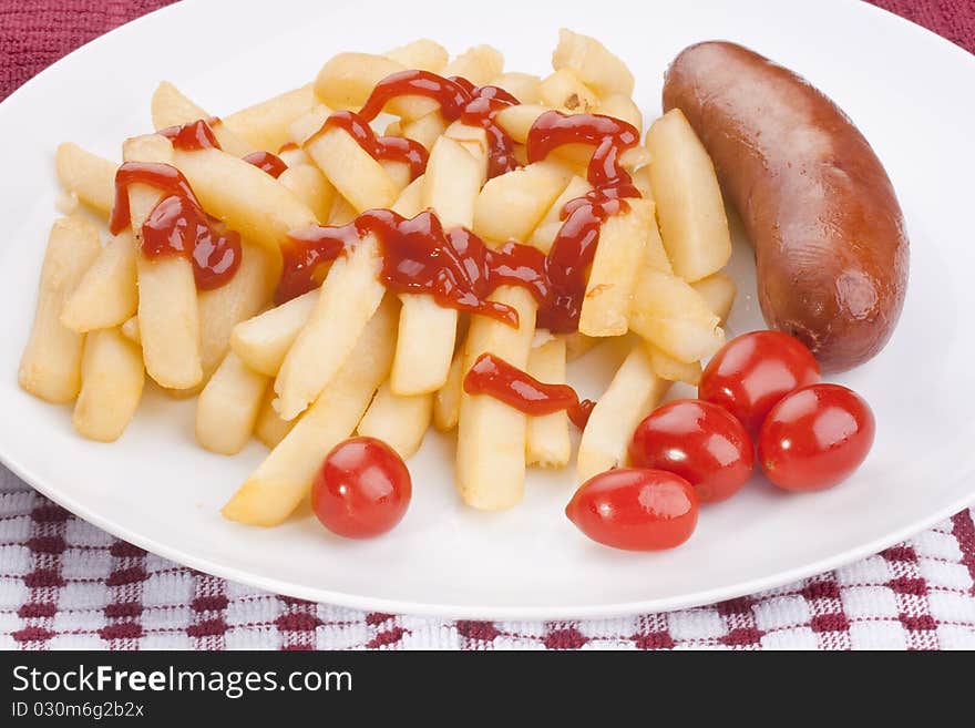 The fried potato is watered by ketchup with sausage and tomatoes.