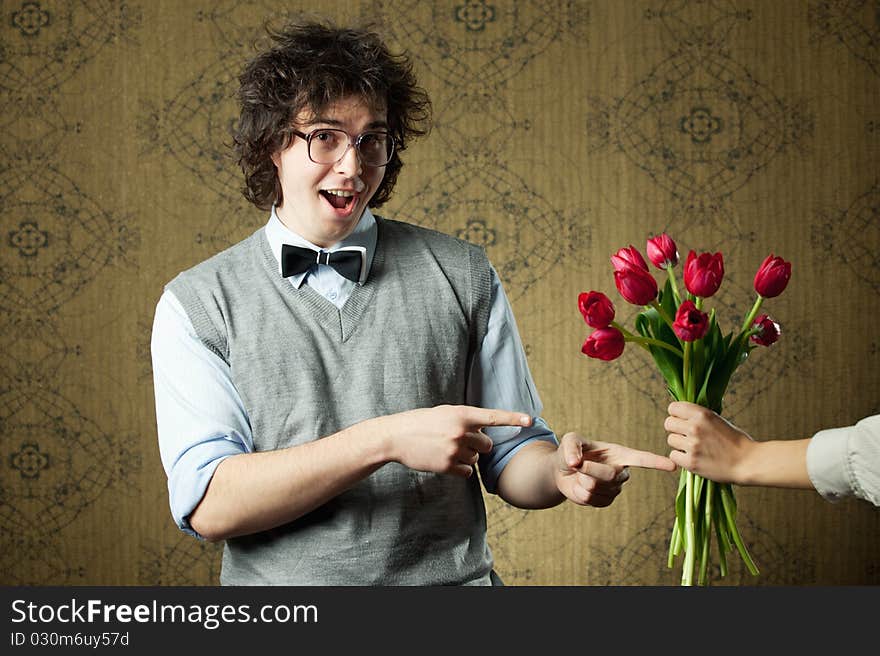 An image of a young man in big glasses and flowers. An image of a young man in big glasses and flowers