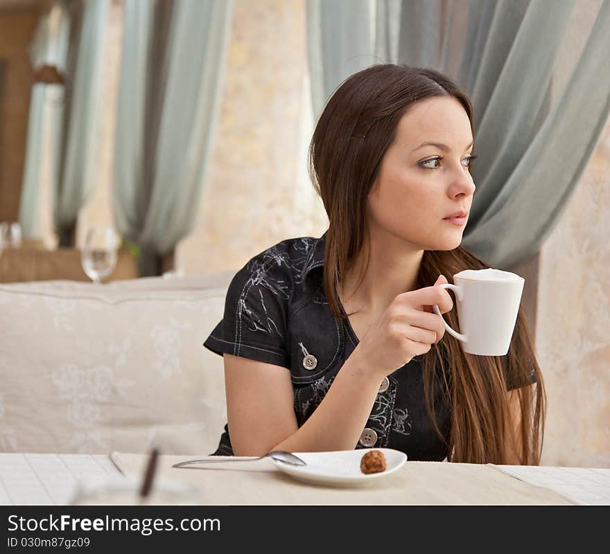 A woman is drinking from a cup