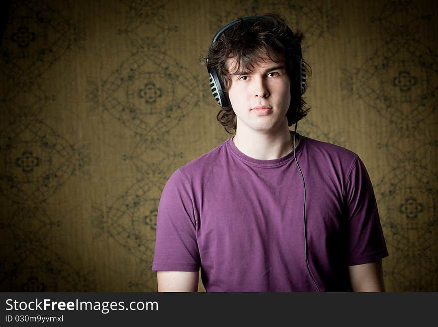 A handsome young man listening to music in headphones