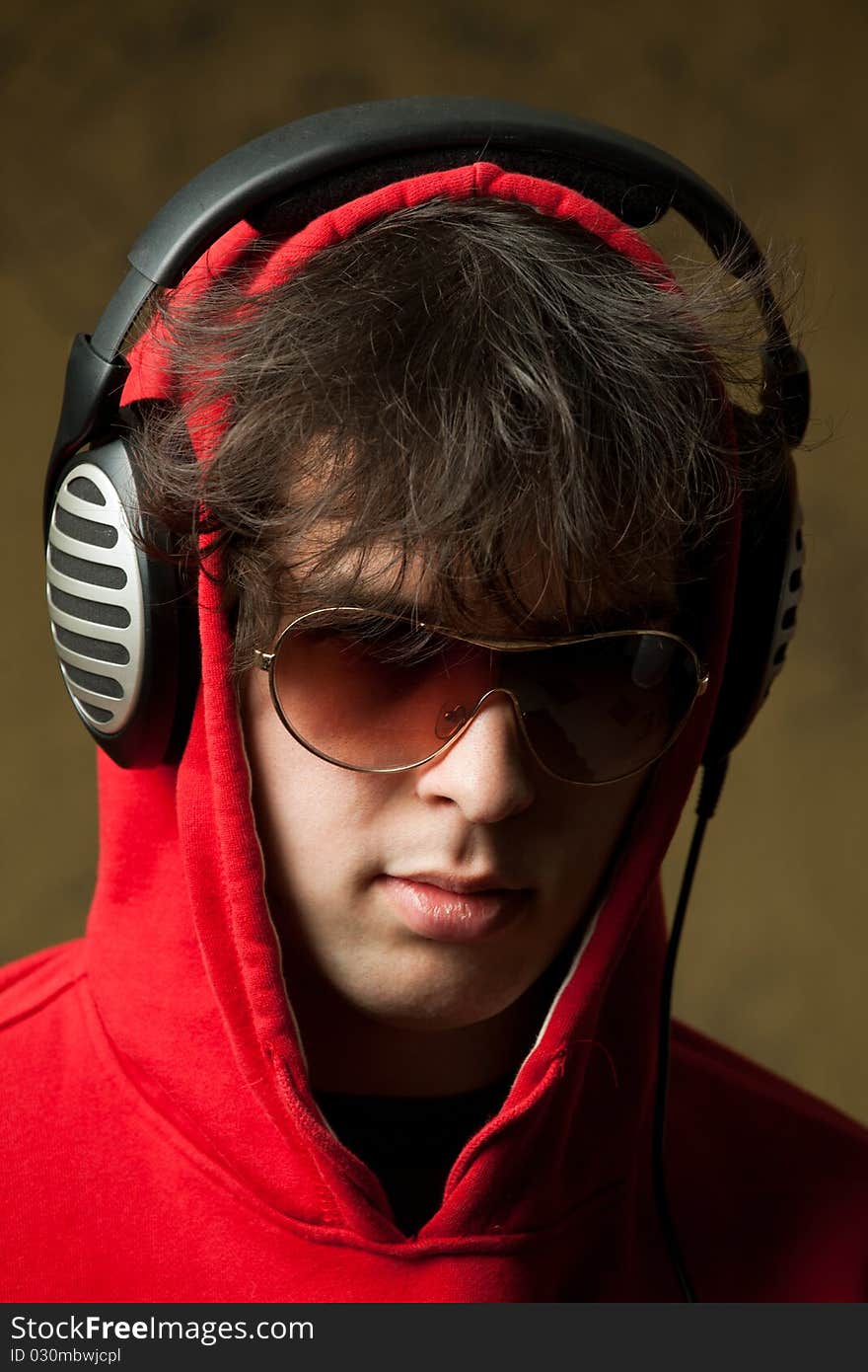 An image of a young man listening to music in headphones. An image of a young man listening to music in headphones