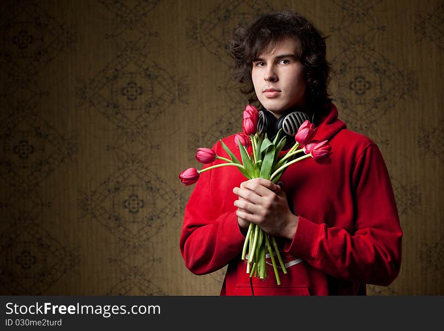 A young man with a bunch of red tulips. A young man with a bunch of red tulips