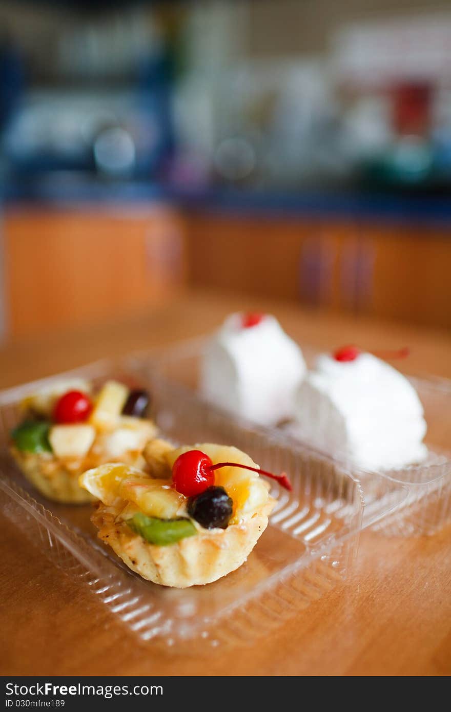 Cupcakes with cherry on top on wooden table. Selective focus.