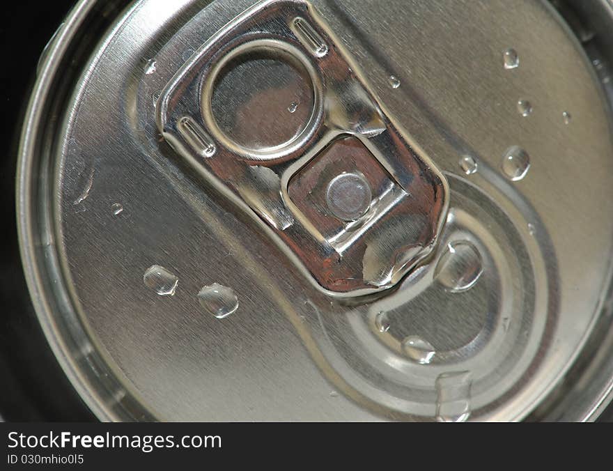 The image is the top of a can, wet from the drops of water, highlight the freshness of the drink. The image is the top of a can, wet from the drops of water, highlight the freshness of the drink.