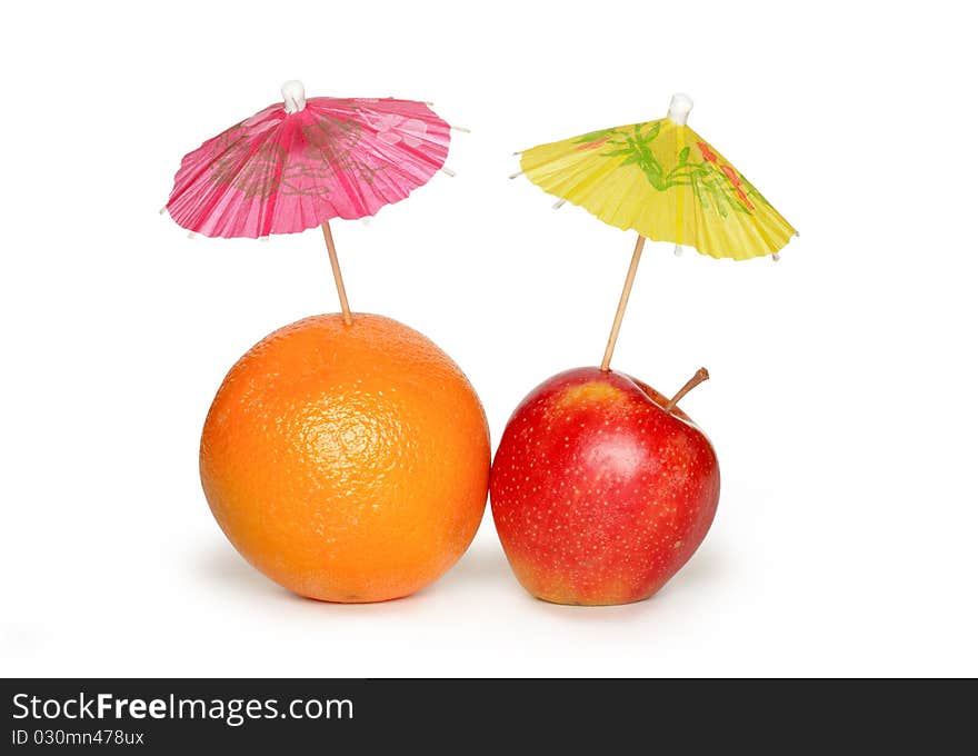 Orange and apple with small paper sunshades on white background. Clipping path included. Orange and apple with small paper sunshades on white background. Clipping path included